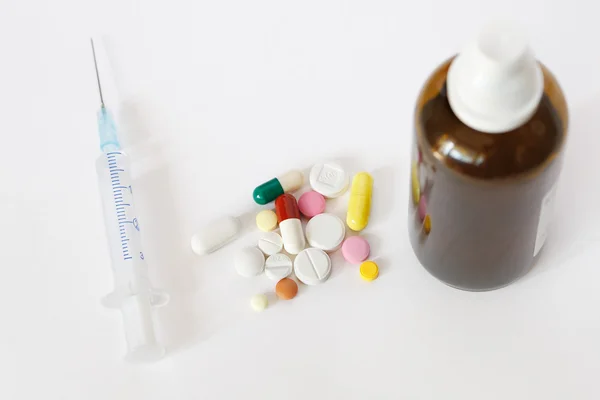 Strzykawka, tabletki i brązowe fiolki — Zdjęcie stockowe