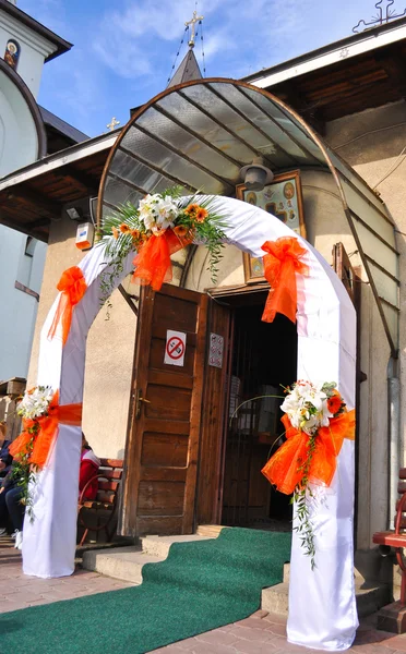 Весільні квіти на вхідних дверях церкви — стокове фото