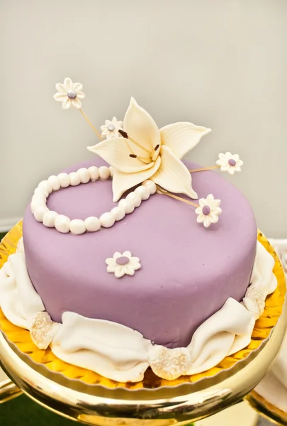 Lila Kuchen mit Lilienblüte Stockbild