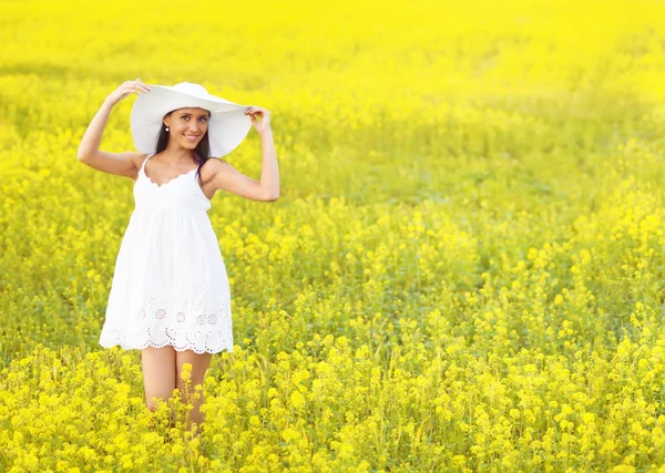 Leende vackra flicka i vit i blommande fält — Stockfoto