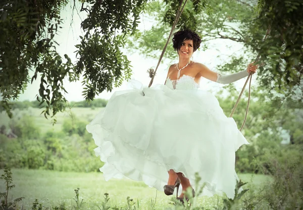 Usmívající se nevěsta na houpačky, venkov pozadí — Stock fotografie