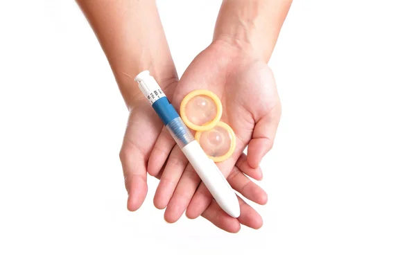 Aiguille de seringue (pour ovule) et préservatif — Photo