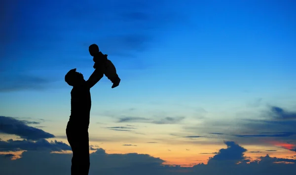 Силует батька і дитини на літньому заході сонця — стокове фото