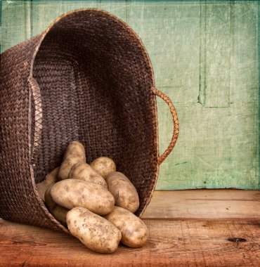 Russet potatoes spilling out of basket clipart