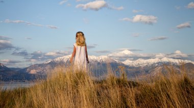 Little girl looking into a mountain landscape clipart