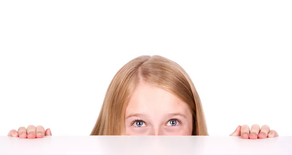 Девушка подглядывает из-за стола — стоковое фото