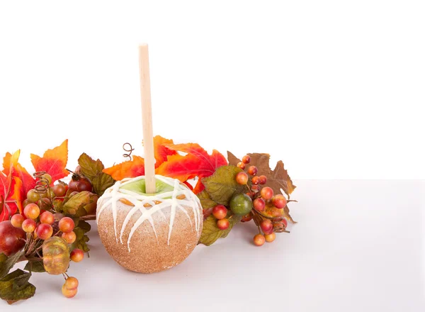 Karmel i czekolada objęte jabłko z liści jesienią — Zdjęcie stockowe