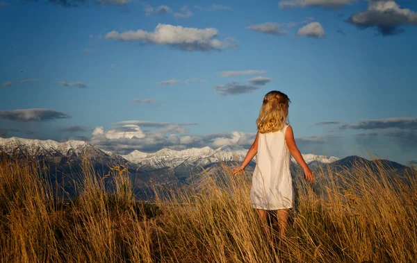 stock image Little girl walking in a mountain landscape