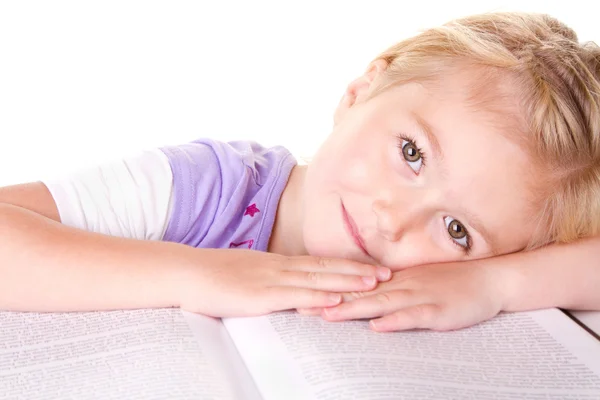 Дошкольная девочка лежит на большой книге — стоковое фото