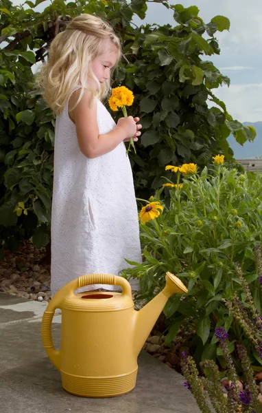 Jovem menina cheirando flores — Fotografia de Stock
