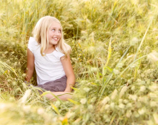 Fille assise dans le champ de blé — Photo