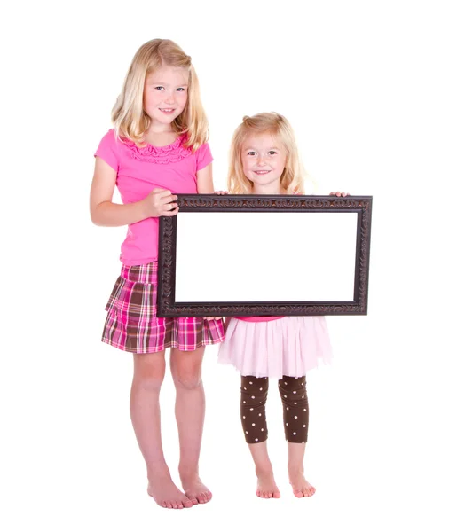 Δύο κορίτσια που κατέχουν ένα κενό πλαίσιο — Φωτογραφία Αρχείου