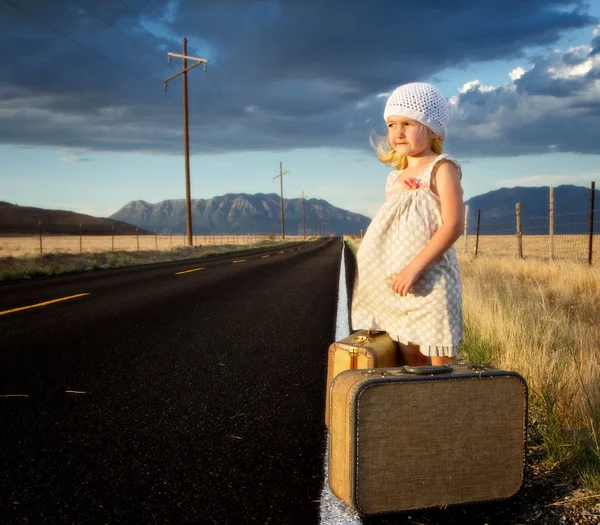 Jeune fille sur le côté de la route avec des valises — Photo