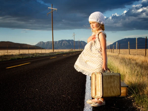 年轻女孩一边的道与行李箱 — 图库照片