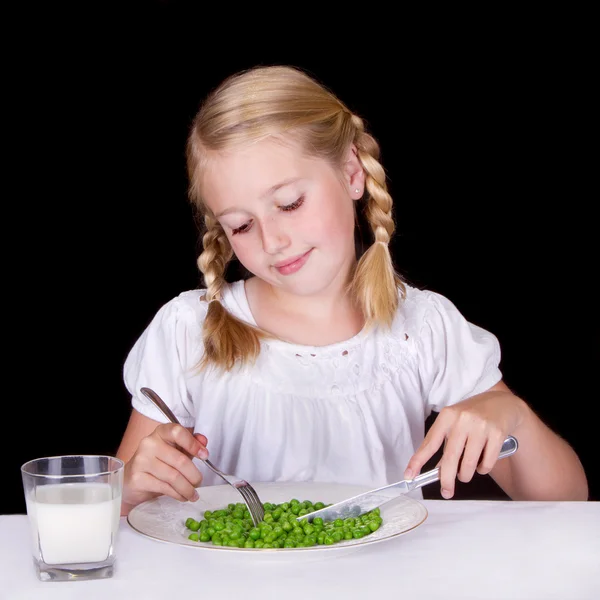 Girl eating peas — Stock Photo, Image