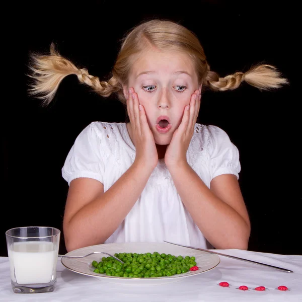 Chica comiendo guisantes con insectos en la mesa —  Fotos de Stock