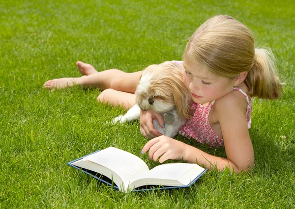 Meisje met hond buiten lezen — Stockfoto