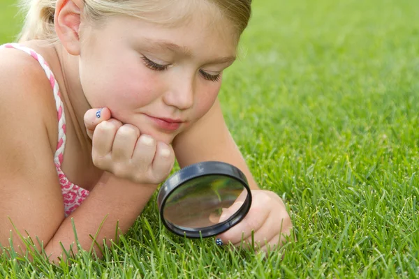 stock image Girl looking through magnifying glass outdoors