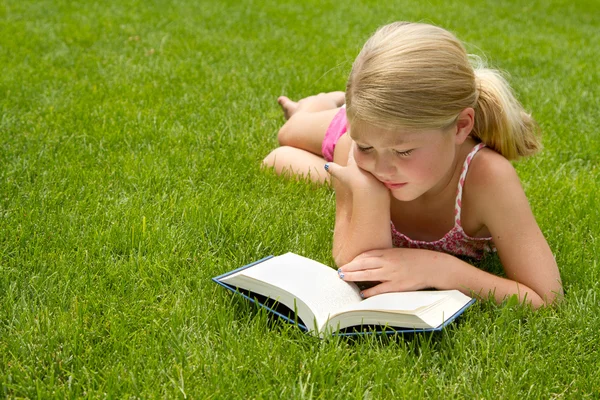 阅读在草丛中的女孩 — 图库照片#
