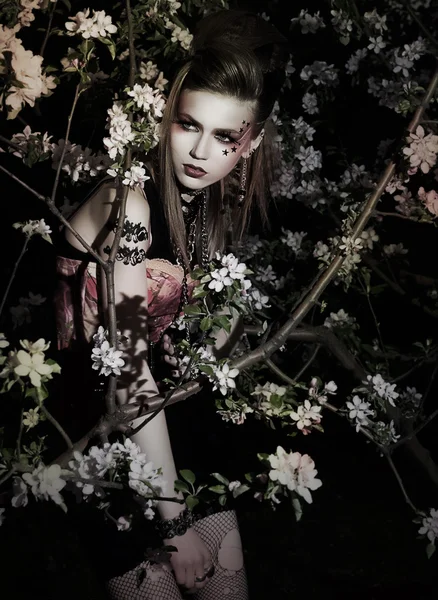 Mooie vrouw met creatieve make-up in tuin — Stockfoto
