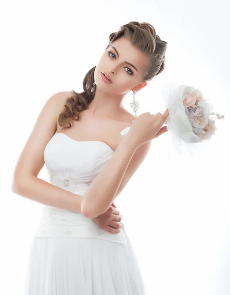 Sinnliche junge Braut mit Blumenstrauß posiert — Stockfoto