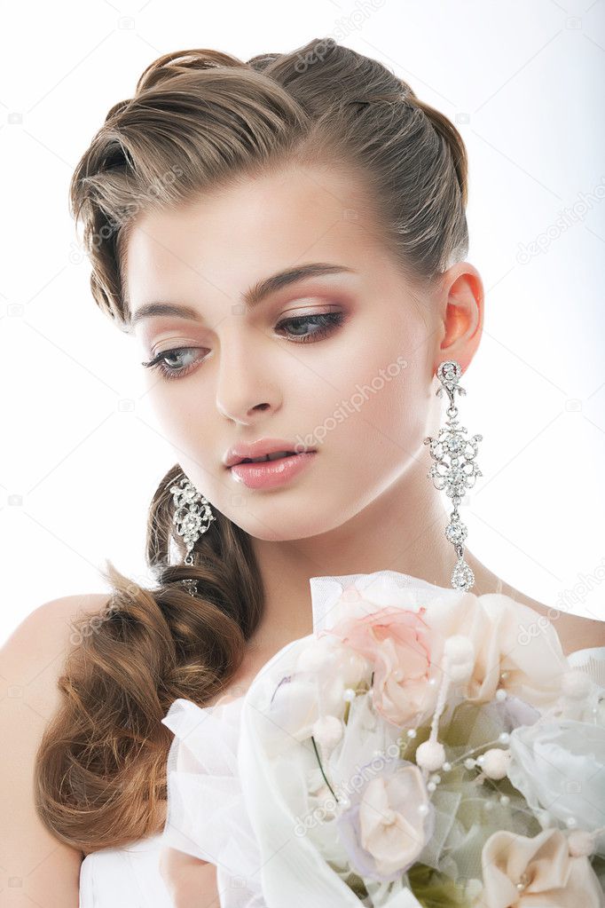 Pretty gentle fashion fiancee with flowers in studio