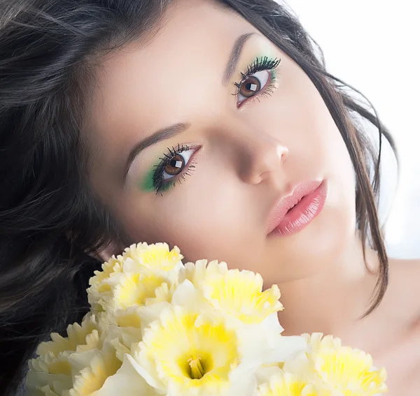 Cute brunette girl with flowers narcissus. Holidays — Stock Photo, Image
