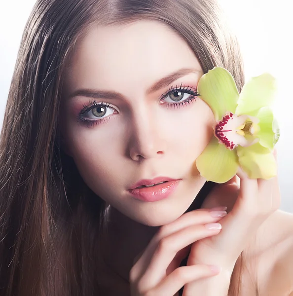 Zdravá čistá dívka tvář - zdravotnictví a krása, květina orchidej — Stock fotografie