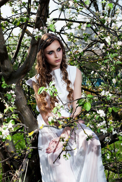 Blossom. Blooming nature and pretty girl sitting