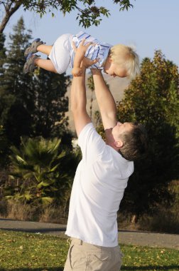 Young infant lifted by father clipart