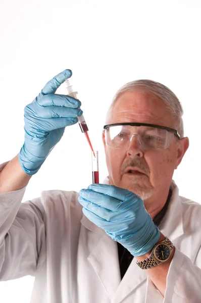Científico investigador que coloca la muestra de sangre en un tubo de ensayo para su análisis —  Fotos de Stock