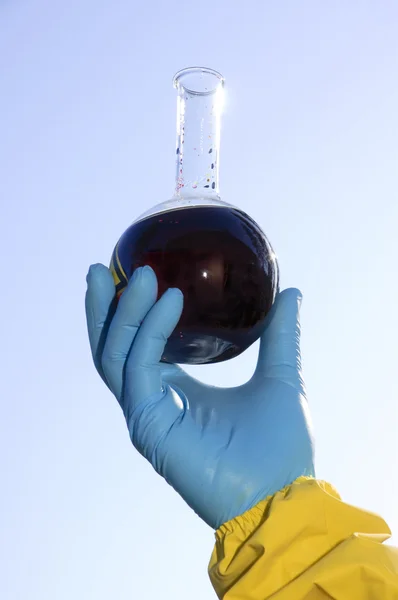 Mão segurando produto químico perigoso — Fotografia de Stock