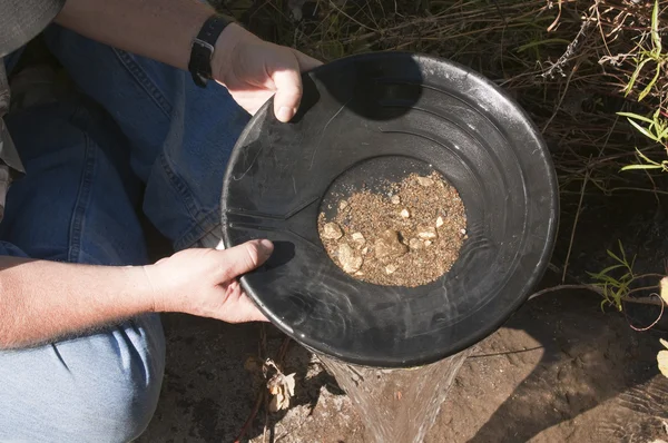 stock image Man pouring water while panning for gold