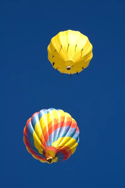 Deux ballons naviguant dans un ciel bleu profond — Photo