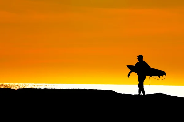 Surfer heading to sea for a sunset ride — Stock Photo, Image