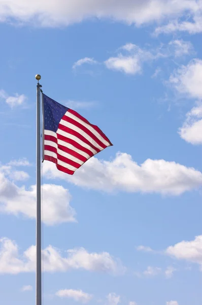 Us Flag waving in the breeze with cumulus clouds in the sky — Stock Photo, Image