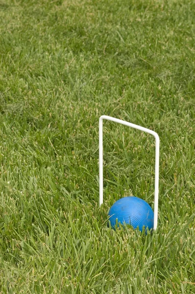 Мяч для крокета сидит под обручем — стоковое фото