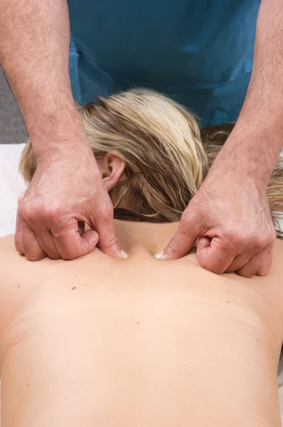 Jovem mulher recebendo uma massagem de um massagista — Fotografia de Stock