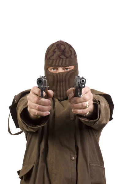 Человек в маске с двумя полуавтоматическими пистолетами, нацеленными на камеру — стоковое фото