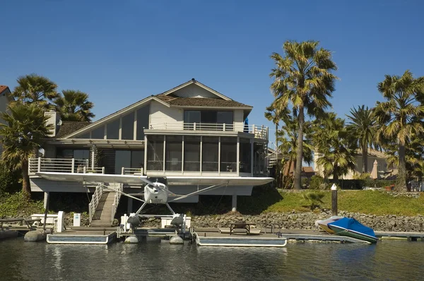 Executive hus på vattnet med sjöflygplan — Stockfoto