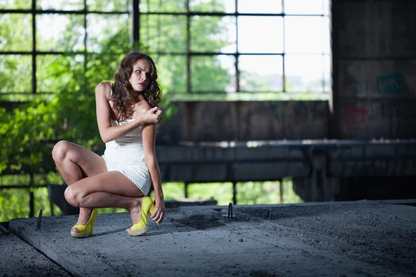 Giovane bruna posa sullo sfondo di un edificio con l — Foto Stock