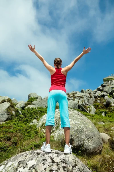 Fitness meisje bovenop de rotsen — Stockfoto