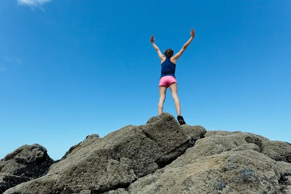Fitness meisje bovenop de rotsen — Stockfoto
