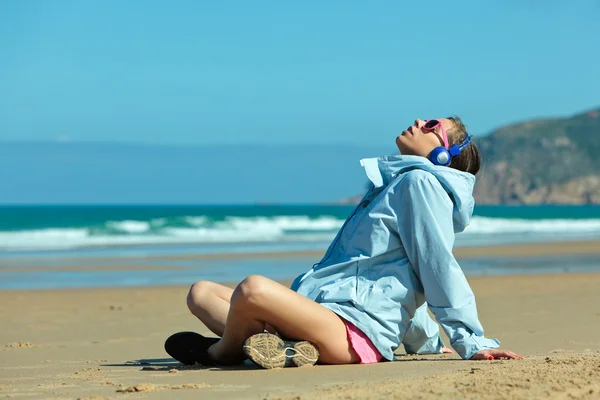 ビーチでヘッドフォンでフィットネス女の子 — ストック写真