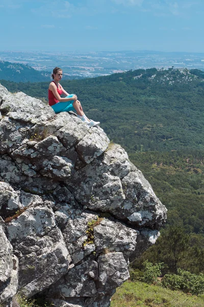 Atletische meisje ontspannen op de top van rotsen — Stockfoto
