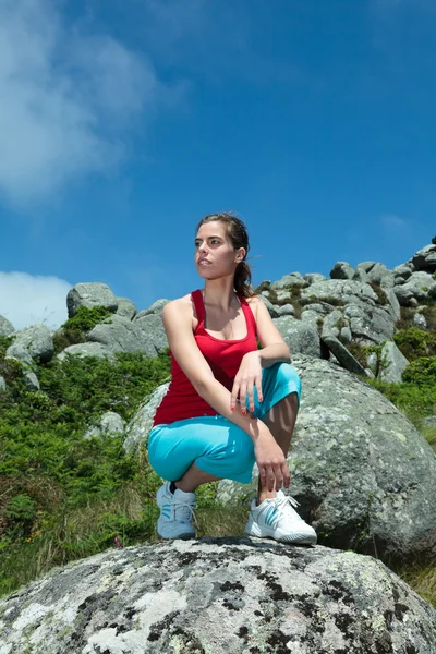 Fitness girl posing on top of rocks — Stock Photo, Image