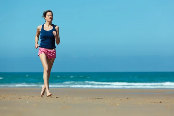Menina correndo na praia em descalço — Fotografia de Stock