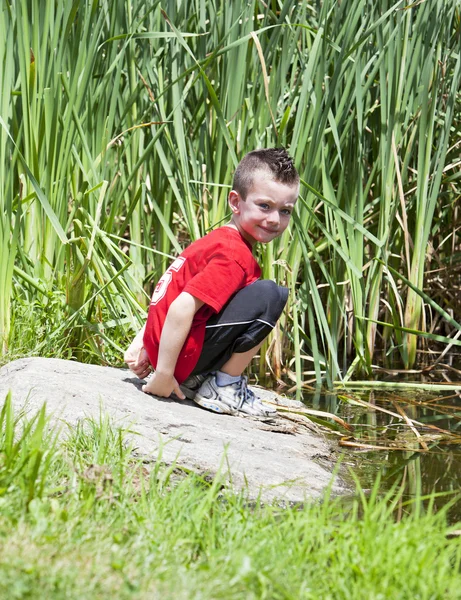 公園の池の近くの若い男の子 — ストック写真