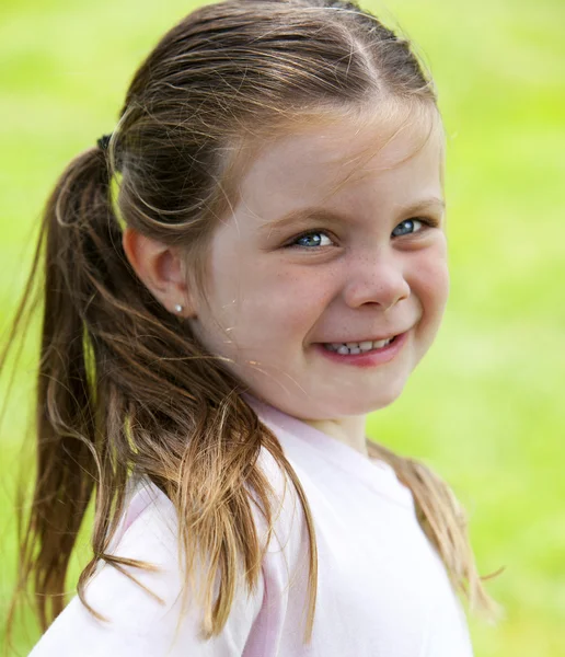 小さな女の子が公園で草 — ストック写真