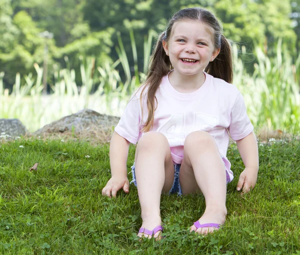 Молода дівчина сміється в траві — стокове фото